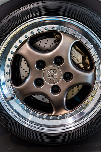 Close-up of Porsche wheel with bronze rim and drilled brake discs