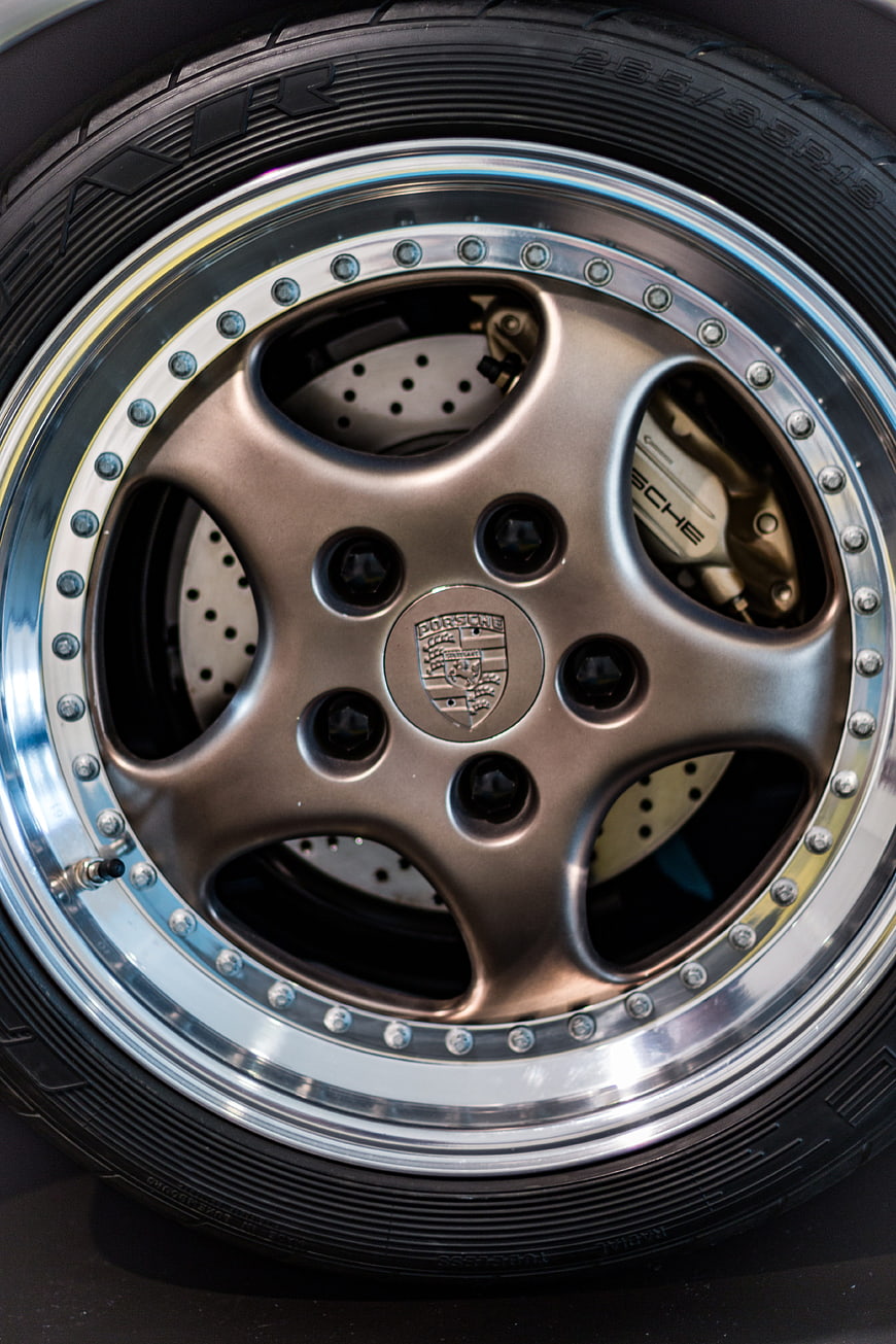 Close-up of Porsche wheel with bronze rim and drilled brake discs