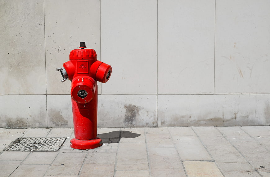 Red Fire Hydrant Against White Wall