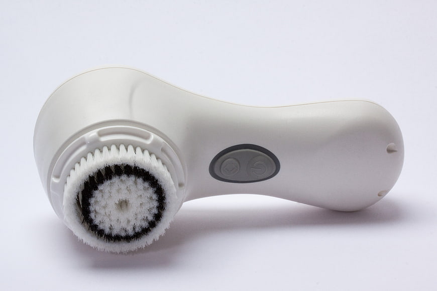White Electric Facial Cleansing Brush With Bristle Head On White Background