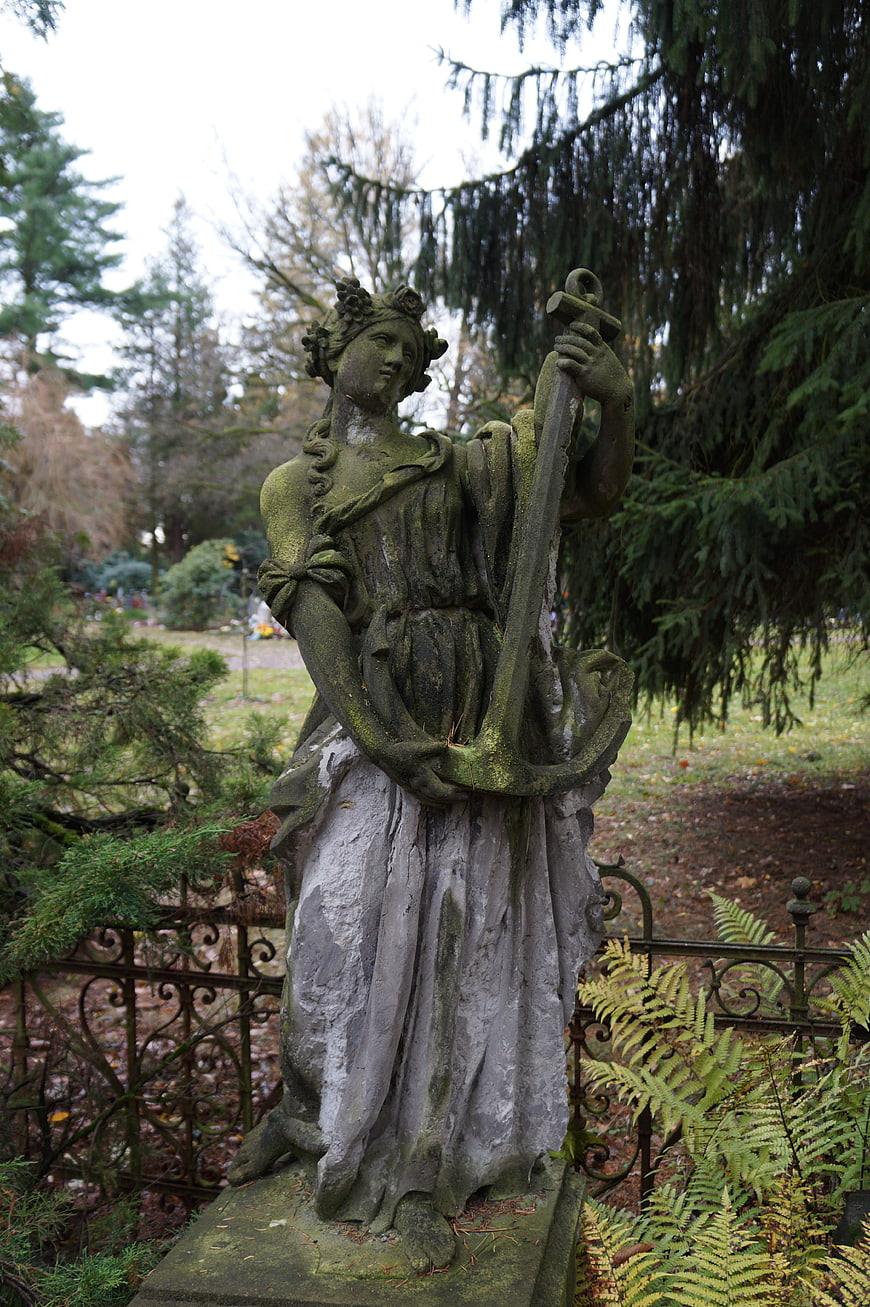Weathered Stone Statue of Woman Holding Anchor in Garden