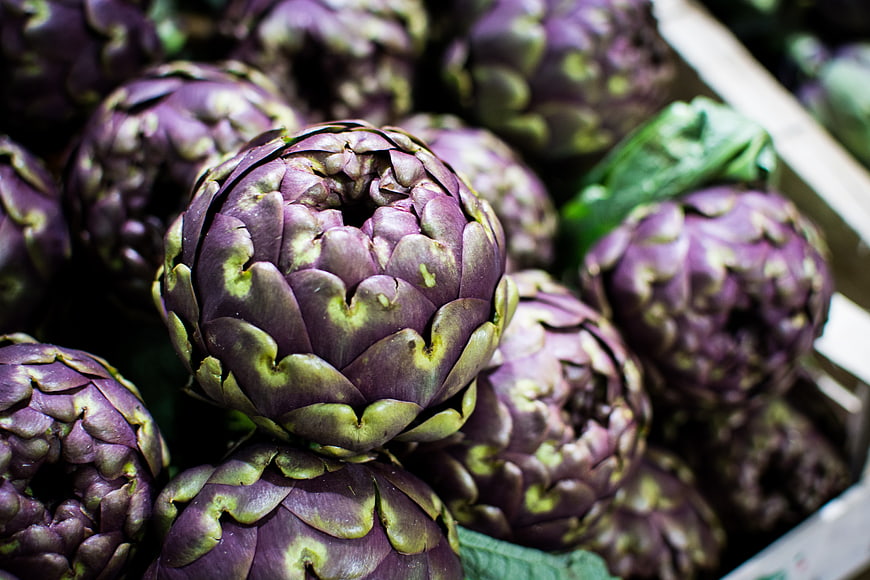 Close-up of fresh purple artichokes in a market crate