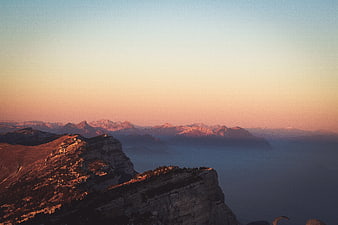 Alpine mountain ridge at sunset with foggy valley
