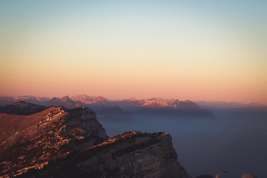 Alpine mountain ridge at sunset with foggy valley