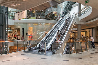 Modern Shopping Mall Interior with Escalators and Stores