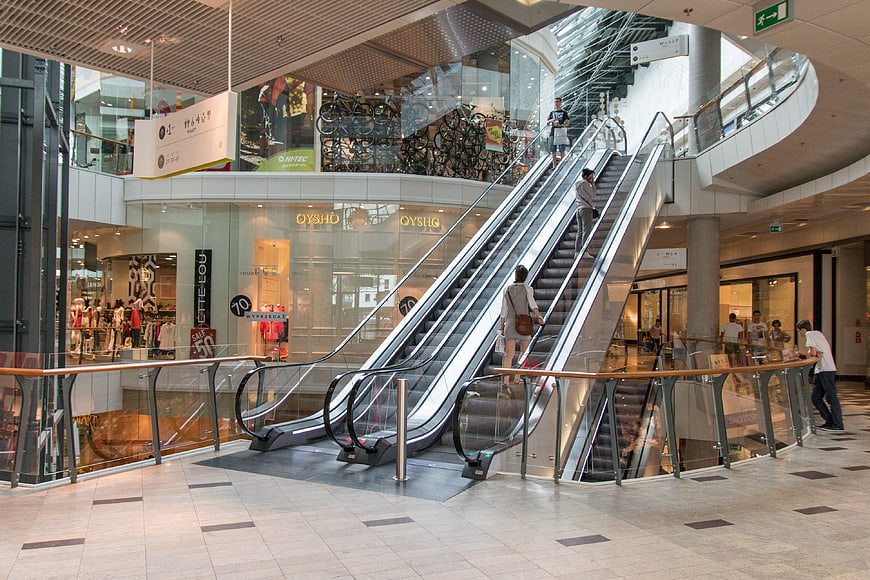 Modern Shopping Mall Interior with Escalators and Stores