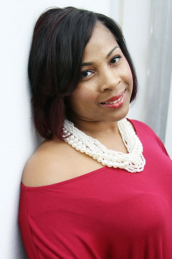 Portrait of Smiling Woman in Red Top with Pearl Necklace