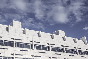 Modern White Geometric Building Facade Against Blue Sky