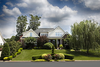 Suburban Brick And White House Exterior With Manicured Front Lawn