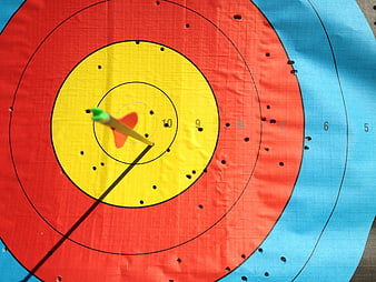 Close-up of archery target with arrow in yellow ring