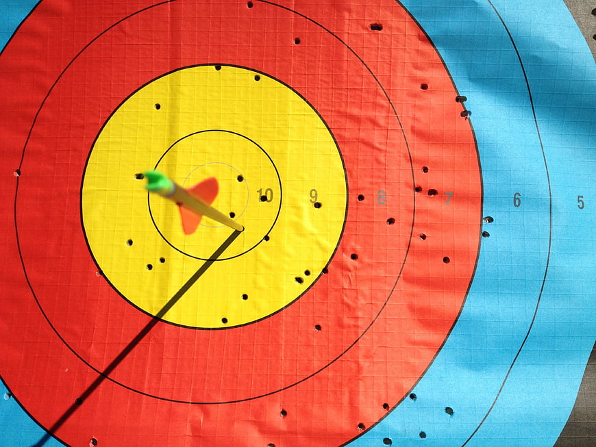 Close-up of archery target with arrow in yellow ring