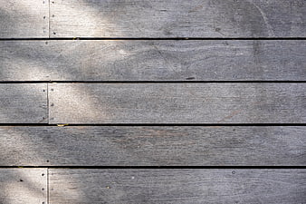 Weathered gray wooden deck planks with natural sunlight texture