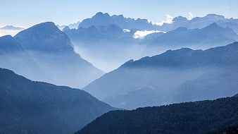 Misty Blue Mountain Range Panorama With Layered Peaks And Forested Valleys