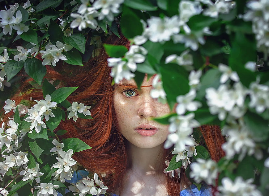 Redhead Woman with Freckles Surrounded by White Jasmine Flowers