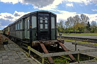 Vintage Railway Carriage on Tracks Under Blue Sky