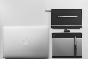 Minimalist Workspace with MacBook, Graphics Tablet, and Notebook