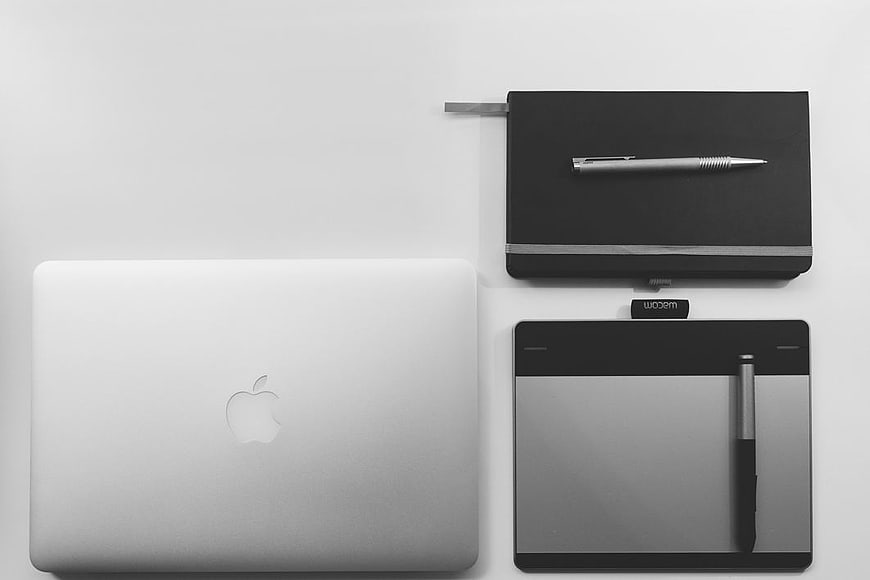 Minimalist Workspace with MacBook, Graphics Tablet, and Notebook
