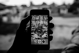 Hand Holding Smartphone with Vintage Camera Wallpaper