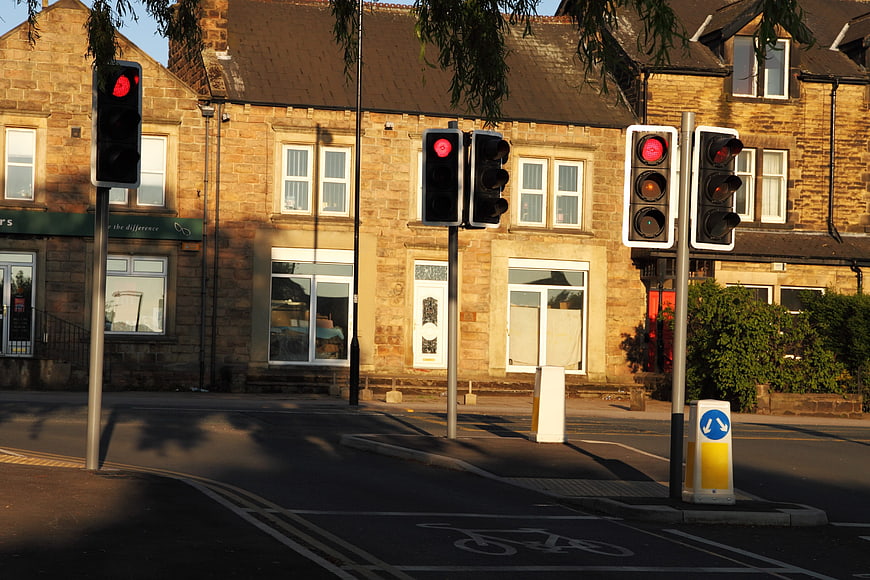 Red traffic lights on a sunny street corner with stone buildings