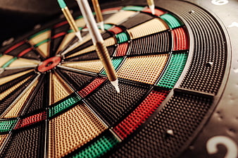 Close-up of darts hitting a dartboard target