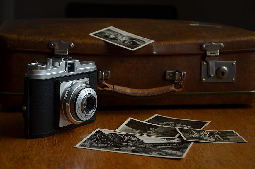 Vintage Camera and Old Photos on Wooden Table