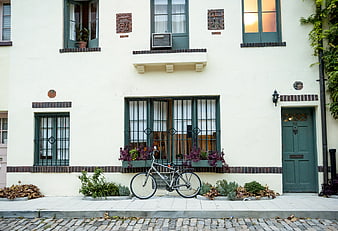 Vintage bicycle parked in front of a cream-colored house facade