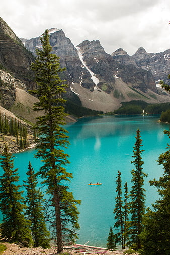 Turquoise Mountain Lake with Canoe and Pine Trees