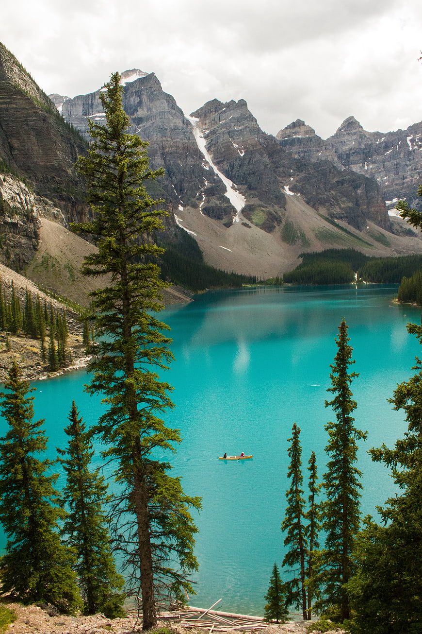 Turquoise Mountain Lake with Canoe and Pine Trees