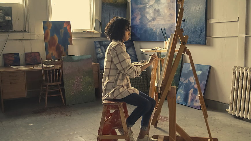 Woman Painting in Art Studio with Easel