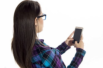 Young woman with glasses using smartphone on white background