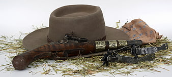 Antique Cowboy Pistol, Hat, Spurs, and Bandana on Hay