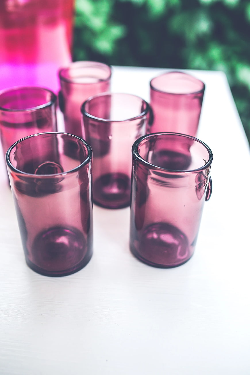Set of pink drinking glasses on white table