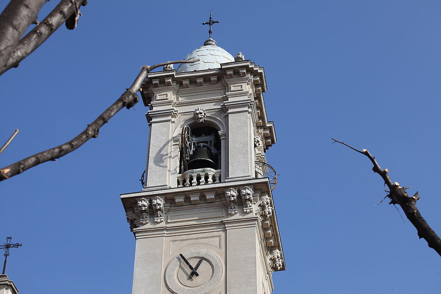 Low angle view of ornate church bell tower against blue sky