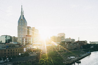 Nashville skyline at sunrise with sun flare over the river
