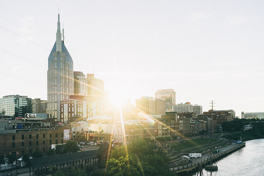 Nashville skyline at sunrise with sun flare over the river