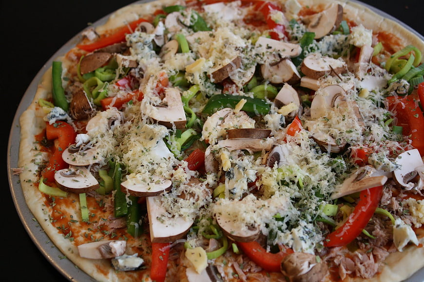 Uncooked homemade pizza with mushrooms and peppers