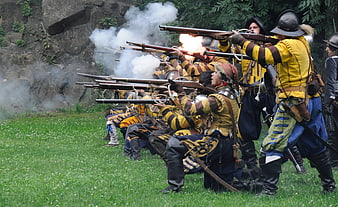 Historical reenactment soldiers firing muskets with smoke