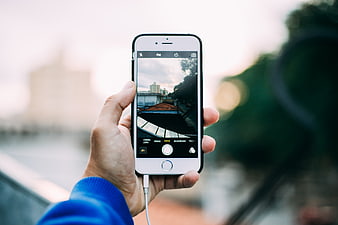 Hand holding smartphone taking photo of cityscape