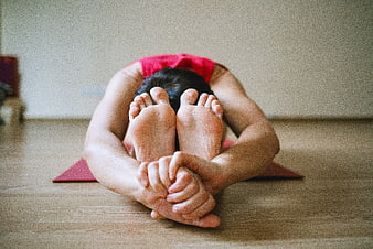 Woman doing yoga forward bend pose on mat