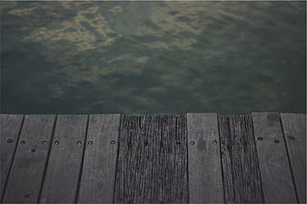 Weathered wooden dock planks over calm lake water