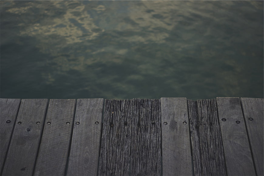 Weathered wooden dock planks over calm lake water