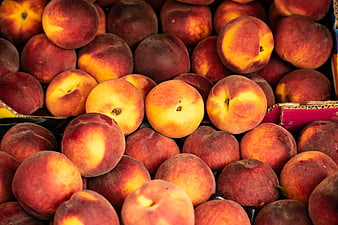 Fresh ripe peaches in a cardboard box at a market