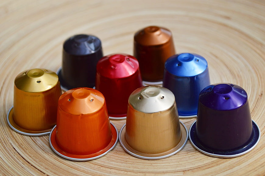 Colorful Coffee Capsules Arranged on Wooden Surface