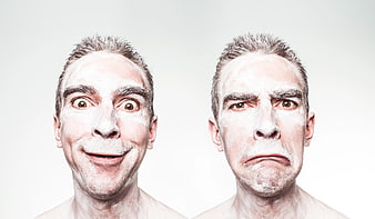Man with white face paint showing happy and sad expressions