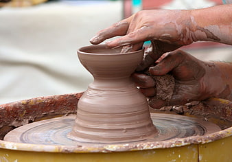 Close-up of hands shaping clay on a spinning potter's wheel