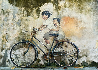 Vintage bicycle in front of mural of children riding bike