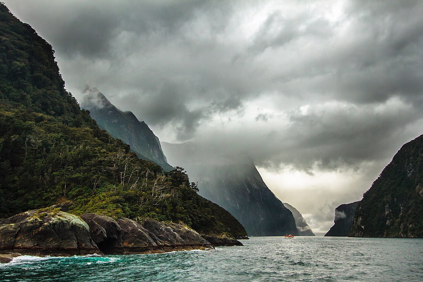 Dramatic Misty Fjord Landscape with Towering Mountains and Turquoise Water