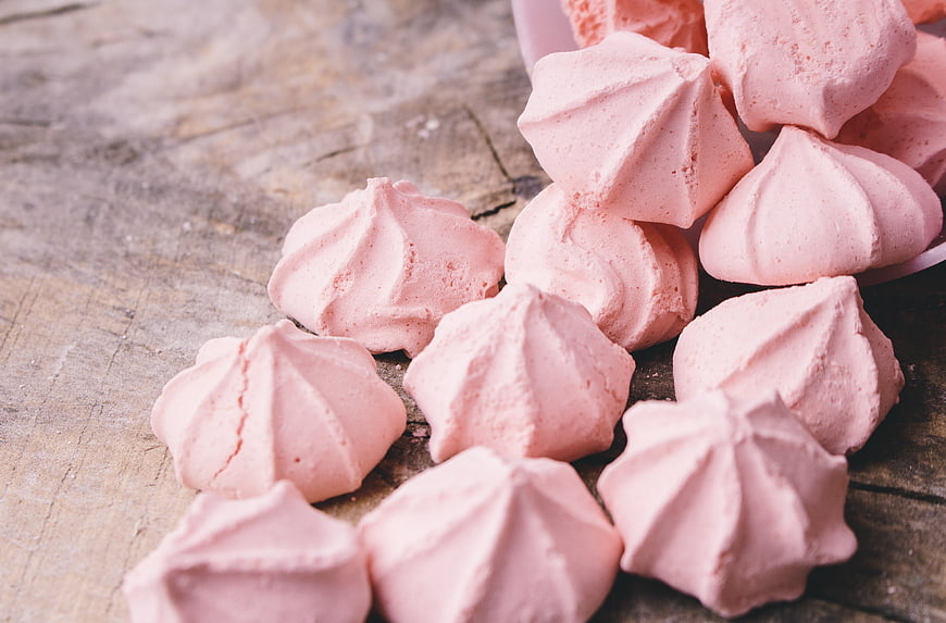 Pink Meringue Cookies Spilled on Rustic Wooden Table