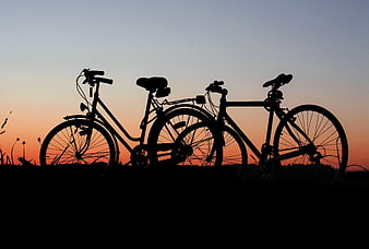 Silhouette of Two Bicycles Against Sunset Sky