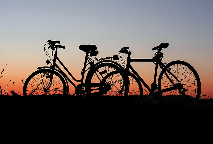 Silhouette of Two Bicycles Against Sunset Sky
